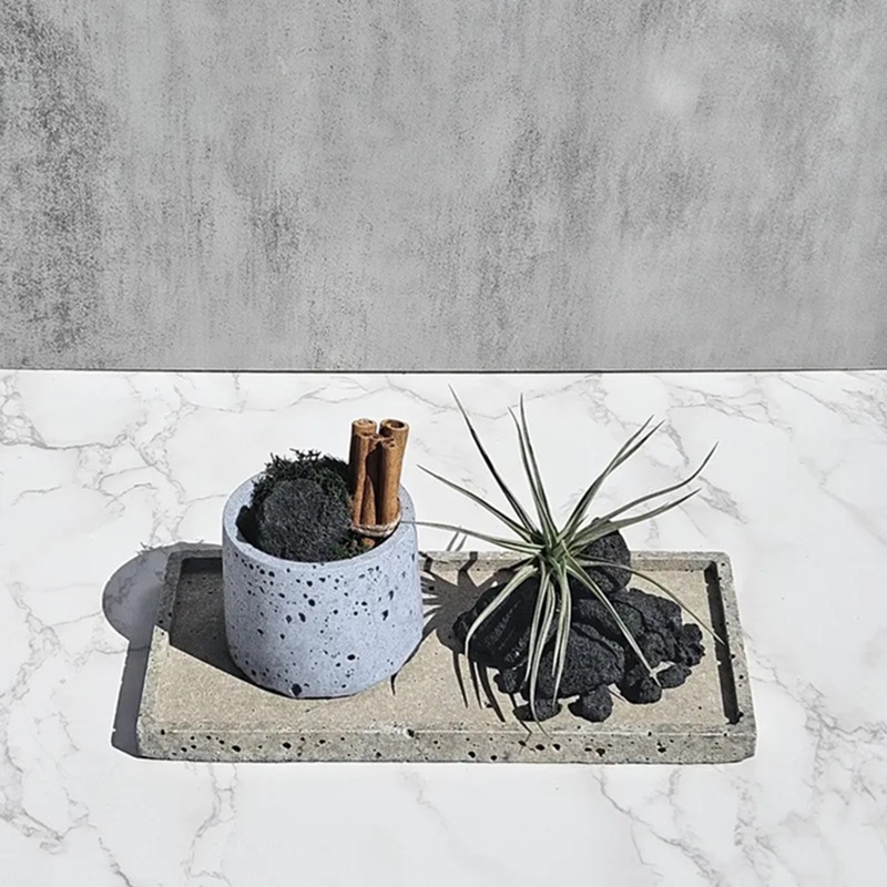 Light beige volcanic texture ceramic tray with blue ceramic container & air plant, styled on marble table